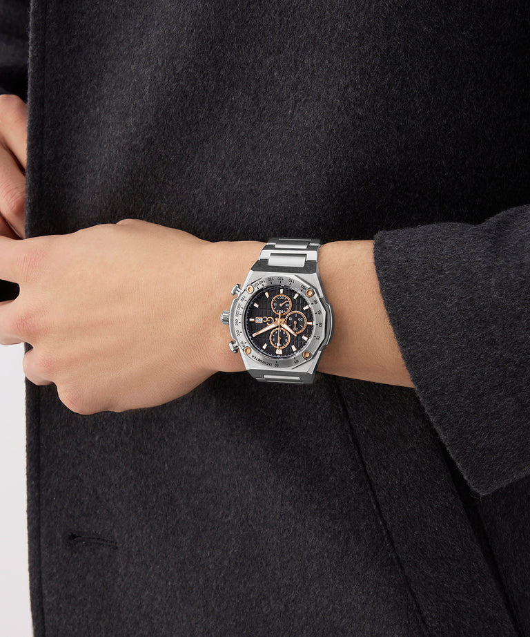 Hand wearing a Gc IdolSport Chrono Metal watch with a black face against a dark background