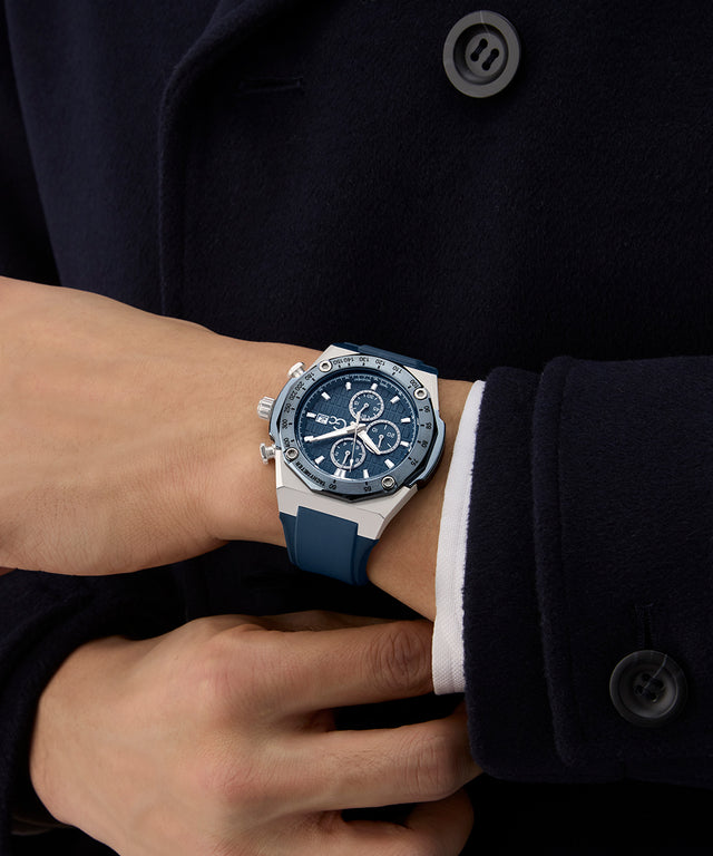 Person wearing a blue Gc IdolSport Chrono Silicone watch on a dark coat background