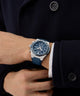 Person wearing a blue Gc IdolSport Chrono Silicone watch on a dark coat background
