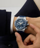 Person wearing a blue and silver Gc IdolSport Chrono Silicone watch on a white background