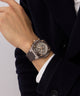Close-up of a wrist wearing a detailed Gc IdolSport Chrono Silicone watch with a dark coat and white shirt.