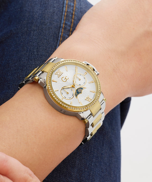 Gold and silver Gc MoonChic Large Size Metal on a wrist with a blurred background