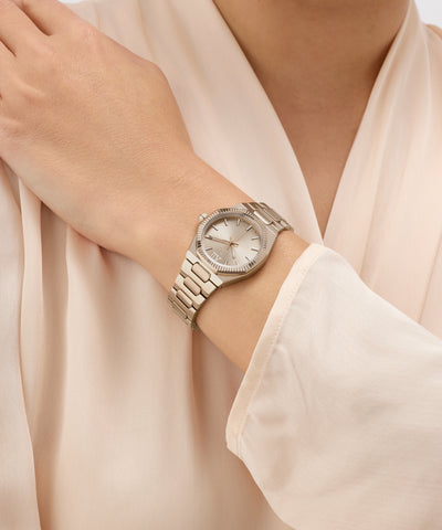 Silver Gc Prodigy Lady Mini Small Size Metal watch on a wrist with a light beige background