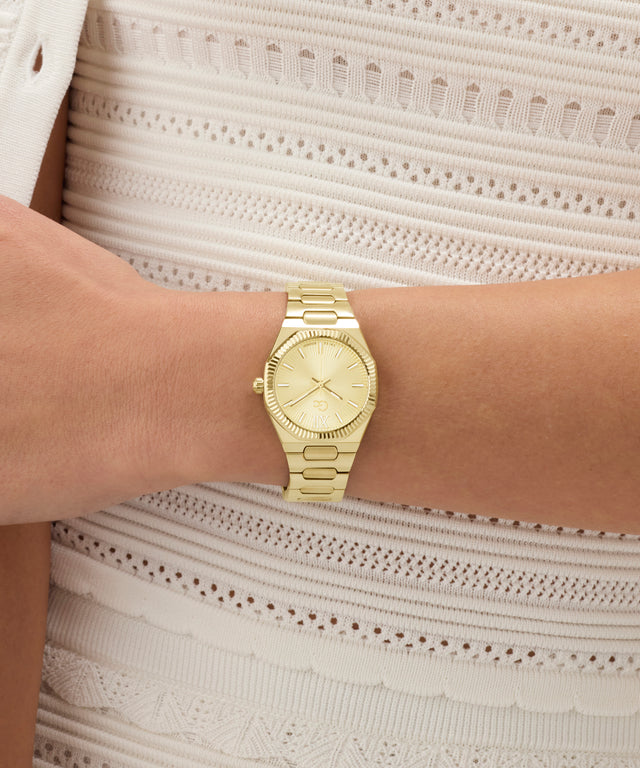 Gold Gc Prodigy Lady Mini Small Size Metal watch on a person's wrist with a light background