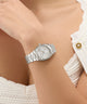 Silver Gc Prodigy Lady Mini Small Size Metal watch on a wrist with a blurred background