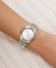 Silver Gc Prodigy Lady Mini Small Size Metal watch on a wrist with a white lace background