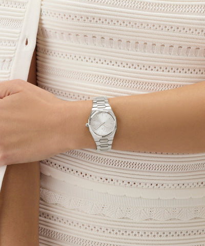 Silver Gc Prodigy Lady Mini Small Size Metal watch on a person's wrist with a light background