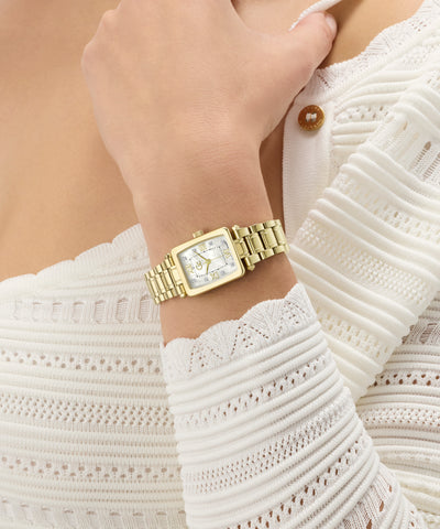 Gold Gc Plaza Mini Small Size Metal watch on a wrist with a white textured garment