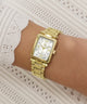 Gold Gc Plaza Mini Small Size Metal wristwatch on a wrist with a textured white background