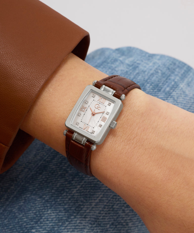 Rectangular Gc Plaza Mini Small Size Leather watch with brown leather strap on wrist against a neutral background