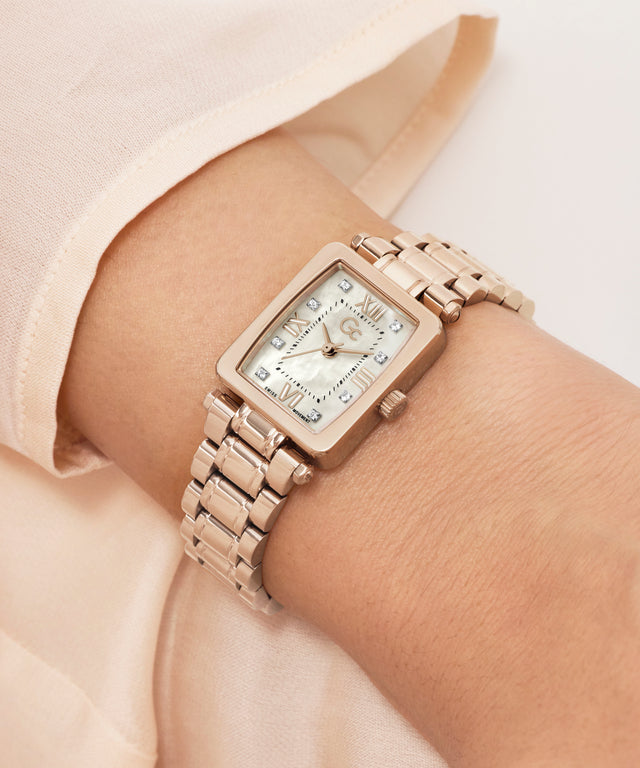 Rose gold Gc Plaza Mini Small Size Metal watch on a wrist with a light background