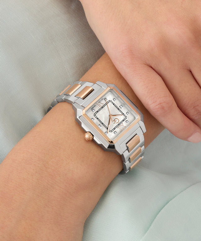 Silver and rose gold Gc SquareCut Lady Mid Size Metal watch on a wrist with a light background