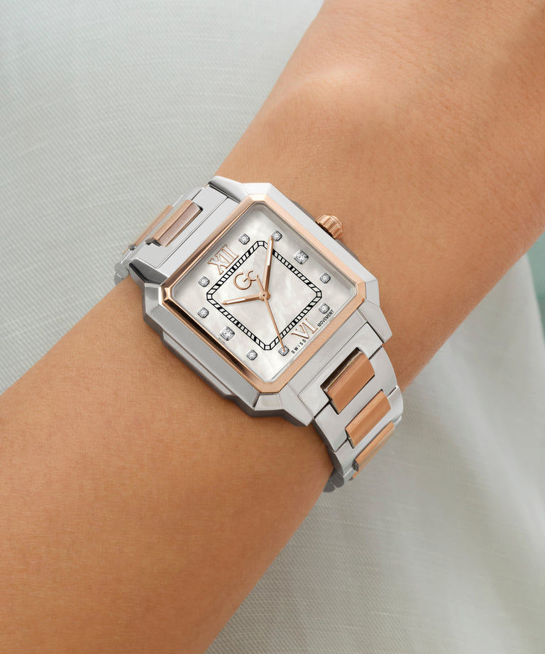 Silver and rose gold Gc SquareCut Lady Mid Size Metal watch on a wrist with a light background