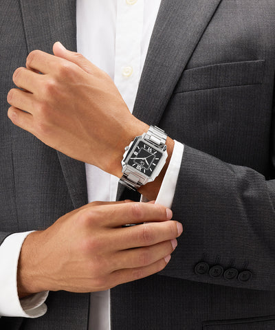 Person wearing a silver Gc SquareCut Metal watch on a gray suit jacket