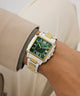 Green Gc SquareCut Metal watch with gold and silver band on a wrist, wearing a beige jacket.
