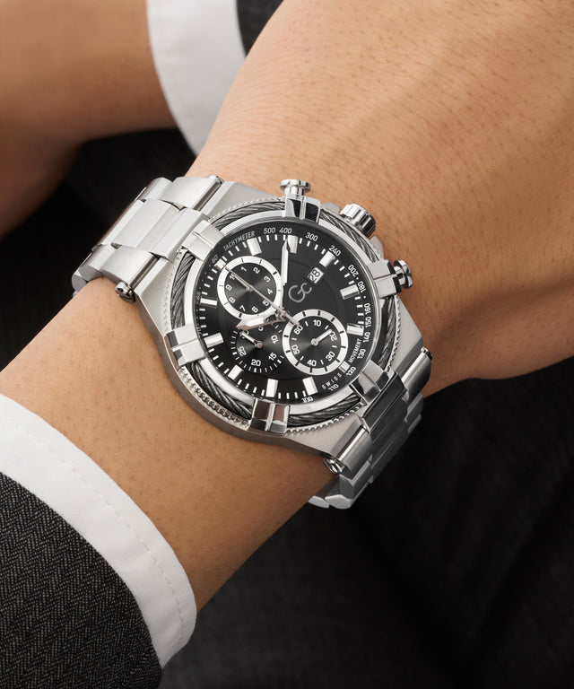 Silver Gc IronForce Chrono Metal with a black face on a person's wrist against a dark background