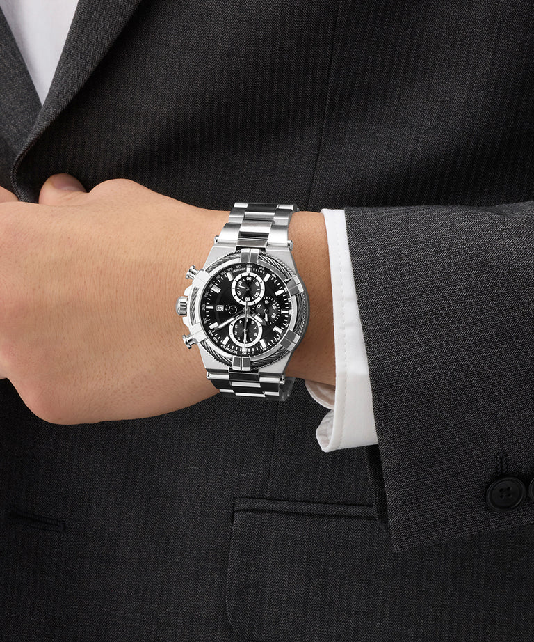 Silver Gc IronForce Chrono Metal on a person's wrist with a dark suit and white shirt