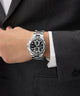 Silver Gc IronForce Chrono Metal on a person's wrist with a dark suit and white shirt