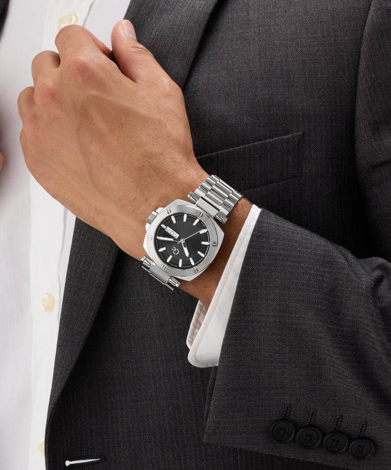 Silver Gc Nobilis Metal on a person wearing a dark suit and white shirt