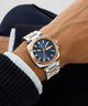 Close-up of a wrist wearing a silver and blue Gc Nobilis Metal with a blurred background
