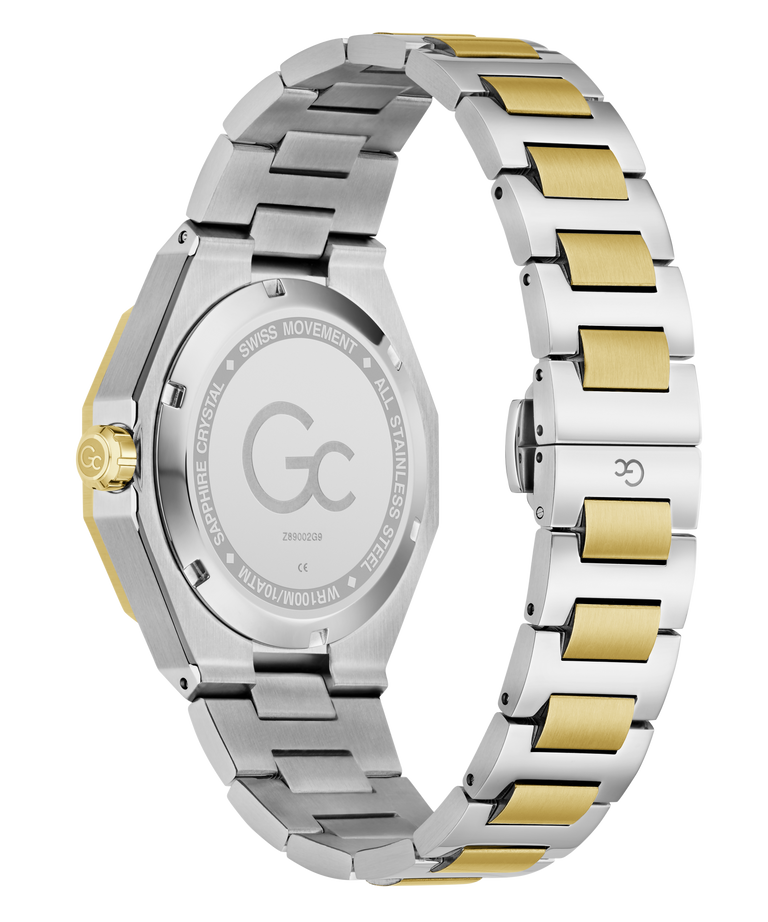 Rear view of a stainless steel and gold-tone watch with a two-tone metal link bracelet, showing the engraved case back and clasp on a white background.