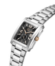 A silver stainless steel men's watch with a black dial, featuring Roman numeral hour markers, a gold-tone crown, and a matching steel link bracelet on a white background. lifestyle
