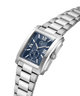 A silver stainless steel wristwatch with a rectangular blue dial, Roman numeral hour markers, and a matching silver metal link bracelet, shown on a plain white background. lifestyle