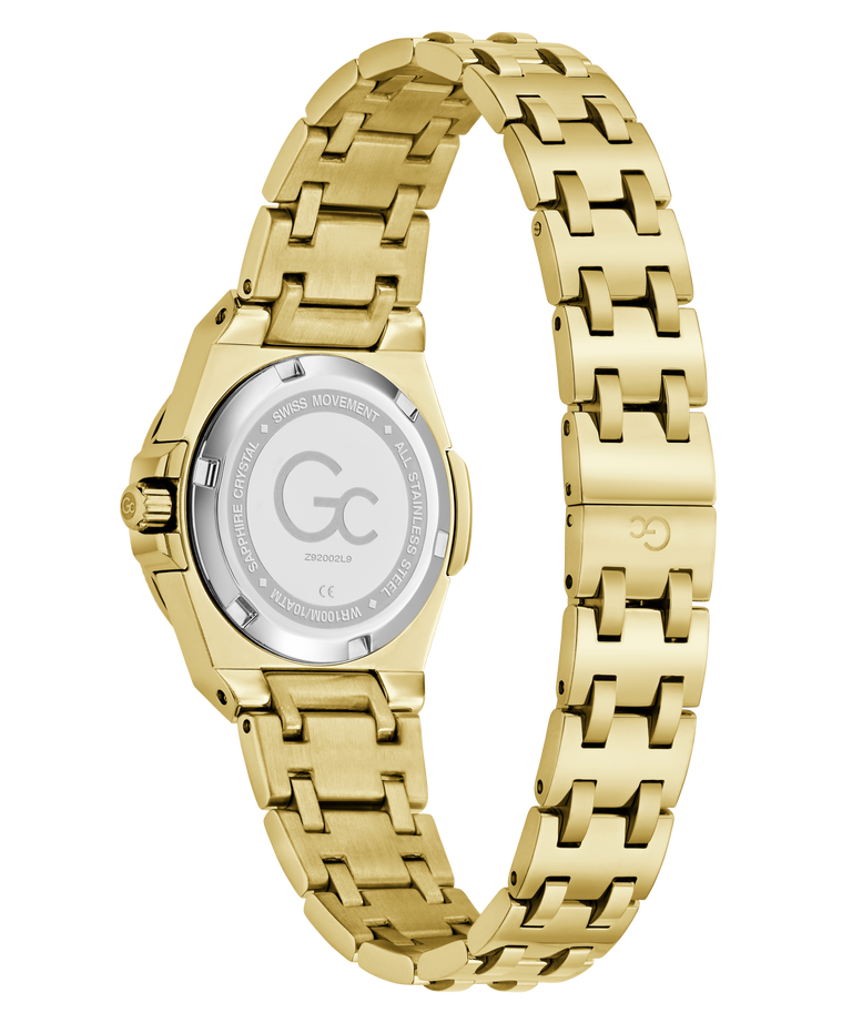 Gold-tone stainless steel watch with a matching link bracelet, shown from the back on a clean white background. The case and bracelet are polished yellow gold, and the back of the case features a silver-toned glass cover with engraved branding and specifications.