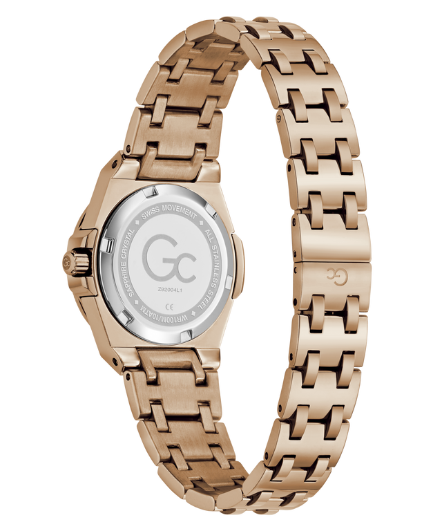 Rose gold women's watch with a stainless steel link bracelet, shown from the back on a white background. The back casing is transparent, revealing the brushed steel case and a silver-toned crystal backplate with a 'Gc' logo and technical specifications.