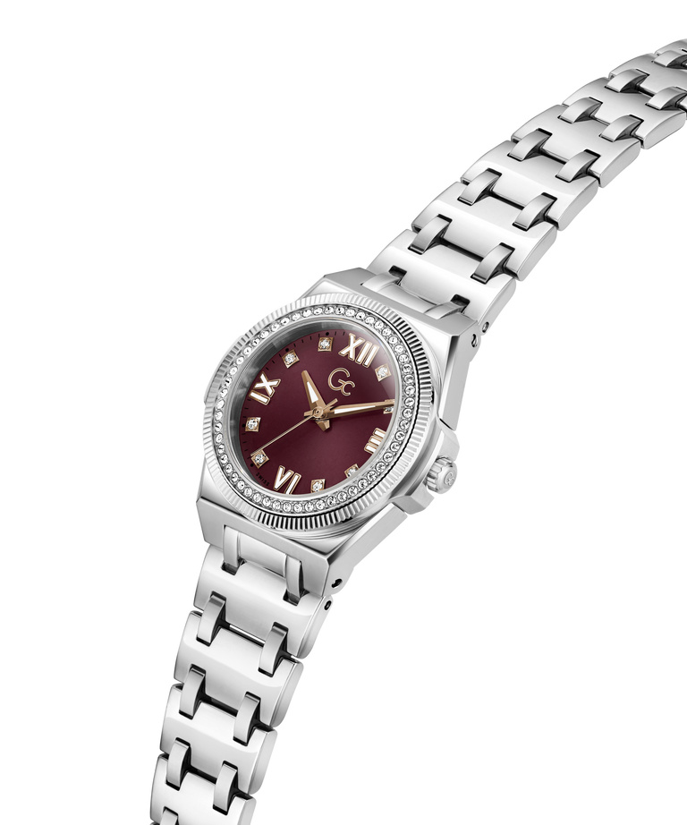 A women's analog watch featuring a silver stainless steel link bracelet, a bezel set with clear crystals, and a deep burgundy dial with gold-tone Roman numerals and hands. lifestyle