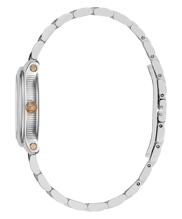 Close-up side view of a silver-tone metal watch with a matching link bracelet, featuring a textured crown guard and a small round rose gold accent on the side.