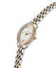 A two-tone oval wristwatch with a silver and rose gold metal link bracelet, a rose gold bezel, and a white dial with Roman numeral hour markers. lifestyle
