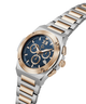 A men's two-tone stainless steel and rose gold chronograph watch with a blue dial, shown on a clean white background. lifestyle