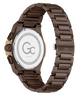 A close-up of a men's watch showing the back of the case and metal link bracelet. The watch has a dark brown anodized metal bracelet and case, with a rose gold-tone crown adjustment on the side.