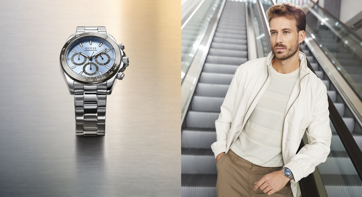 Mens silver watch with blue dial at left and man standing to the right wearing the watch